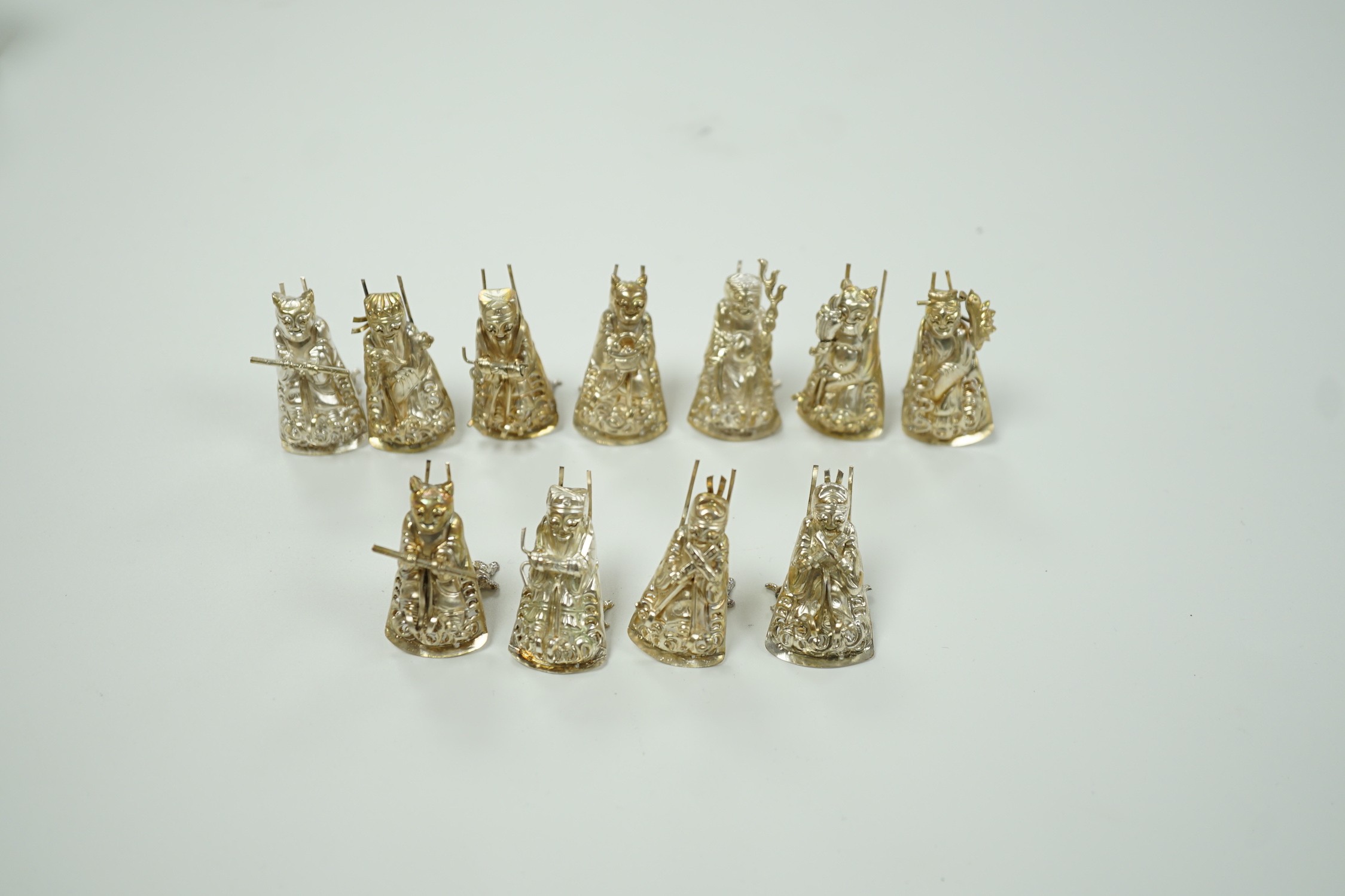 A set of eleven Chinese white metal menu card supports, in the form of artisans, 41mm.